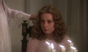 Movie still from “La Cage aux Folles” (1978), directed by Édouard Molinaro – A woman with long curly hair is getting her hair done; Close Up shot, Over the shoulder angle