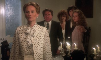 Movie still from “La Cage aux Folles” (1978), directed by Édouard Molinaro – A group of people standing around a table; Medium shot, Over the shoulder angle
