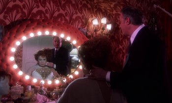 Movie still from “La Cage aux Folles” (1978), directed by Édouard Molinaro – A man and a woman looking in a mirror; Medium shot, Over the shoulder angle