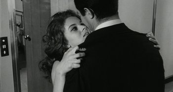 Movie still from “La Notte” (1961), directed by Michelangelo Antonioni – A man and a woman embracing each other in black and white; Close Up shot, Over the shoulder angle