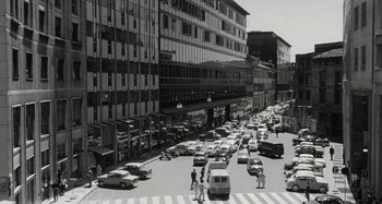 Movie still from “La Notte” (1961), directed by Michelangelo Antonioni – A black - and - white photo of a busy city street; Extreme Wide shot, High angle