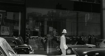 Movie still from “La Notte” (1961), directed by Michelangelo Antonioni – A black and white photo of a man in a white suit; Wide shot, Low angle