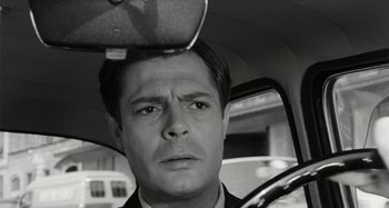 Movie still from “La Notte” (1961), directed by Michelangelo Antonioni – A black and white photo of a man in the back of a car; Close Up shot, Low angle