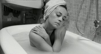 Movie still from “La Notte” (1961), directed by Michelangelo Antonioni – A woman with a towel wrapped around her head in a bath tub; Close Up shot, High angle