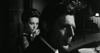 Movie still from “La Notte” (1961), directed by Michelangelo Antonioni – A man smoking a cigarette next to a woman; Close Up shot, Low angle