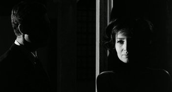 Movie still from “La Notte” (1961), directed by Michelangelo Antonioni – A black - and - white photo of a woman in a dark room; Close Up shot, Over the shoulder angle