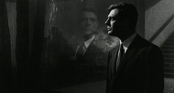 Movie still from “La Notte” (1961), directed by Michelangelo Antonioni – A black and white photo of a man in front of a mirror; Close Up shot, Low angle