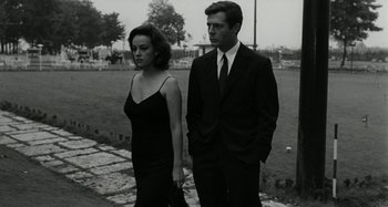 Movie still from “La Notte” (1961), directed by Michelangelo Antonioni – A man and a woman standing next to each other; Medium shot, Low angle
