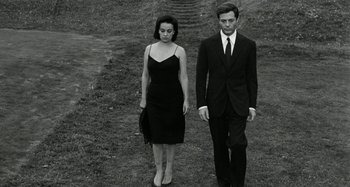 Movie still from “La Notte” (1961), directed by Michelangelo Antonioni – A man and a woman standing next to each other; Medium shot, Low angle