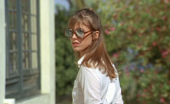 Movie still from “The Swimming Pool” (1969), directed by Jacques Deray – A woman wearing a white shirt and a pair of sunglasses; Close Up shot, Low angle