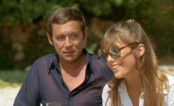 Movie still from “The Swimming Pool” (1969), directed by Jacques Deray – A man and a woman are standing next to each other; Close Up shot, Over the shoulder angle