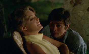 Movie still from “The Swimming Pool” (1969), directed by Jacques Deray – A man and a woman sitting next to each other; Close Up shot, Low angle