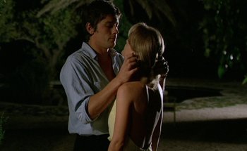 Movie still from “The Swimming Pool” (1969), directed by Jacques Deray – A man and a woman are standing in the dark; Medium shot, Low angle
