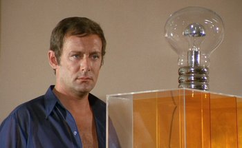 Movie still from “The Swimming Pool” (1969), directed by Jacques Deray – A man standing in front of an electric lamp; Close Up shot, Low angle