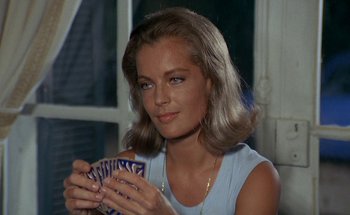 Movie still from “The Swimming Pool” (1969), directed by Jacques Deray – A beautiful woman holding a deck of playing cards; Close Up shot, Over the shoulder angle