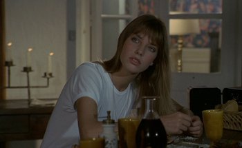 Movie still from “The Swimming Pool” (1969), directed by Jacques Deray – A beautiful young lady sitting at a dinner table; Close Up shot, Over the shoulder angle