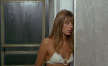 Movie still from “The Swimming Pool” (1969), directed by Jacques Deray – A woman in a white bra leaning against a wall; Close Up shot, Over the shoulder angle