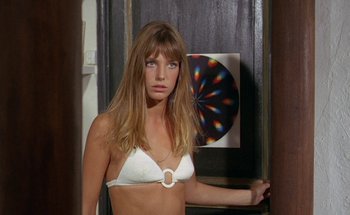 Movie still from “The Swimming Pool” (1969), directed by Jacques Deray – A woman in a white bikini standing in front of a mirror; Medium shot, High angle