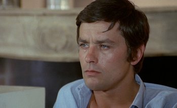 Movie still from “The Swimming Pool” (1969), directed by Jacques Deray – A person wearing a blue shirt; Close Up shot, High angle