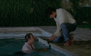 Movie still from “The Swimming Pool” (1969), directed by Jacques Deray – A man and a woman in a pool of water; Wide shot, High angle