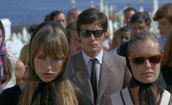 Movie still from “The Swimming Pool” (1969), directed by Jacques Deray – A group of people standing next to each other wearing sunglasses; Close Up shot, Low angle