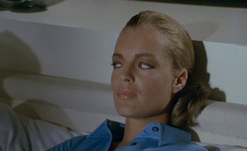 Movie still from “The Swimming Pool” (1969), directed by Jacques Deray – A person wearing a blue shirt; Close Up shot, High angle