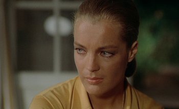 Movie still from “The Swimming Pool” (1969), directed by Jacques Deray – A person wearing a yellow shirt; Close Up shot, Over the shoulder angle