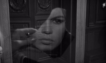 Movie still from “The Truth” (1960), directed by Henri-Georges Clouzot – A black - and - white photo of a woman looking through a window; Extreme Close Up shot, Over the shoulder angle