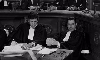 Movie still from “The Truth” (1960), directed by Henri-Georges Clouzot – Two men are sitting at a table in front of a judge; Medium shot, High angle