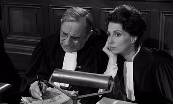 Movie still from “The Truth” (1960), directed by Henri-Georges Clouzot – An older man and a younger woman are sitting in a courtroom; Medium shot, High angle