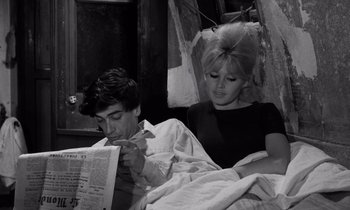 Movie still from “The Truth” (1960), directed by Henri-Georges Clouzot – A man and a woman in bed reading a newspaper; Medium shot, High angle
