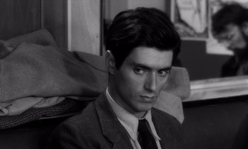 Movie still from “The Truth” (1960), directed by Henri-Georges Clouzot – Black and white photograph of a man in a suit and neck tie; Close Up shot, Over the shoulder angle