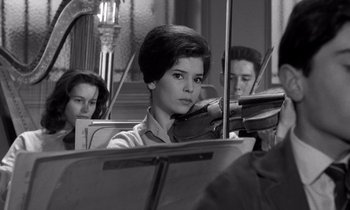 Movie still from “The Truth” (1960), directed by Henri-Georges Clouzot – A woman is playing the violin while two other people watch; Close Up shot, Low angle