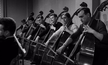 Movie still from “The Truth” (1960), directed by Henri-Georges Clouzot – A black and white photo of a group of men playing the cello; Medium shot, Low angle
