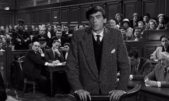 Movie still from “The Truth” (1960), directed by Henri-Georges Clouzot – A black and white photo of a man in a courtroom; Medium shot, Low angle