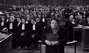 Movie still from “The Truth” (1960), directed by Henri-Georges Clouzot – A woman is holding a book in front of a group of people; Medium shot, High angle