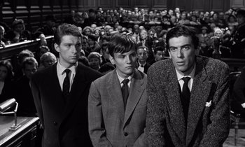 Movie still from “The Truth” (1960), directed by Henri-Georges Clouzot – A group of men standing in front of a crowd; Medium shot, High angle