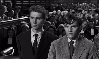 Movie still from “The Truth” (1960), directed by Henri-Georges Clouzot – Two men in suits standing next to each other in front of a group of onlookers; Close Up shot, High angle