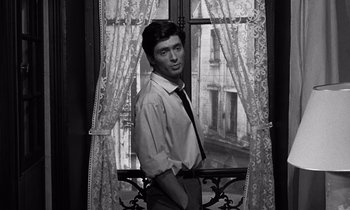 Movie still from “The Truth” (1960), directed by Henri-Georges Clouzot – A black and white photo of a man standing in front of a window; Medium shot, Low angle