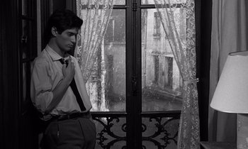 Movie still from “The Truth” (1960), directed by Henri-Georges Clouzot – A man standing in front of an open window; Medium shot, Over the shoulder angle