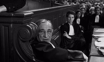 Movie still from “The Truth” (1960), directed by Henri-Georges Clouzot – A man sitting in front of two other people in a courtroom; Medium shot, High angle