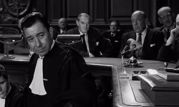 Movie still from “The Truth” (1960), directed by Henri-Georges Clouzot – A black and white photo of a judge in a courtroom; Medium shot, Low angle