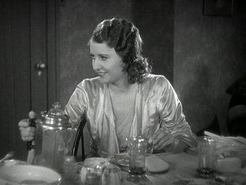 Movie still from “Ladies of Leisure” (1930), directed by Frank Capra – A woman sitting at a table with a glass of water; Medium shot, High angle