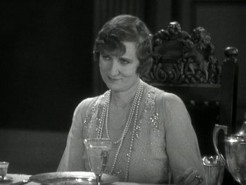 Movie still from “Ladies of Leisure” (1930), directed by Frank Capra – An older woman sitting at a table with a glass of wine; Close Up shot, High angle