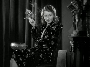 Movie still from “Ladies of Leisure” (1930), directed by Frank Capra – A woman sitting in a chair holding a pipe; Medium shot, Low angle