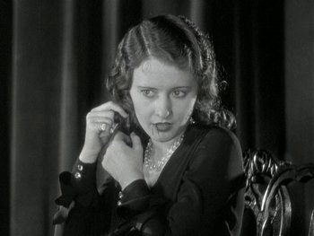 Movie still from “Ladies of Leisure” (1930), directed by Frank Capra – A woman in a black dress holding a pair of earrings; Close Up shot, High angle