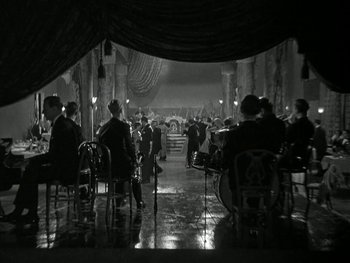 Movie still from “Ladies of Leisure” (1930), directed by Frank Capra – A group of people sitting at tables in a room; Extreme Wide shot, High angle
