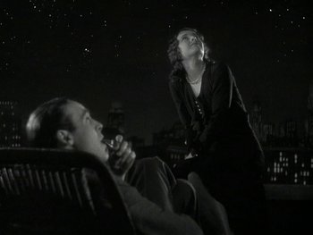 Movie still from “Ladies of Leisure” (1930), directed by Frank Capra – A man and a woman sitting on a chair in the dark; Medium shot, Low angle