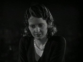 Movie still from “Ladies of Leisure” (1930), directed by Frank Capra – A black and white photo of a woman with a pearl necklace; Close Up shot, High angle