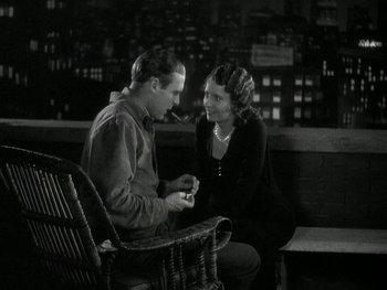Movie still from “Ladies of Leisure” (1930), directed by Frank Capra – A man and a woman sitting on a wooden bench; Medium shot, High angle